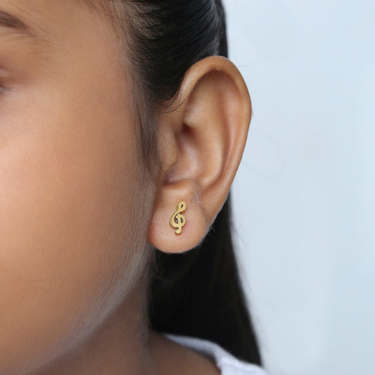 Girl wearing Cute Music Note gold earrings – kids jewellery by Twisty Locks